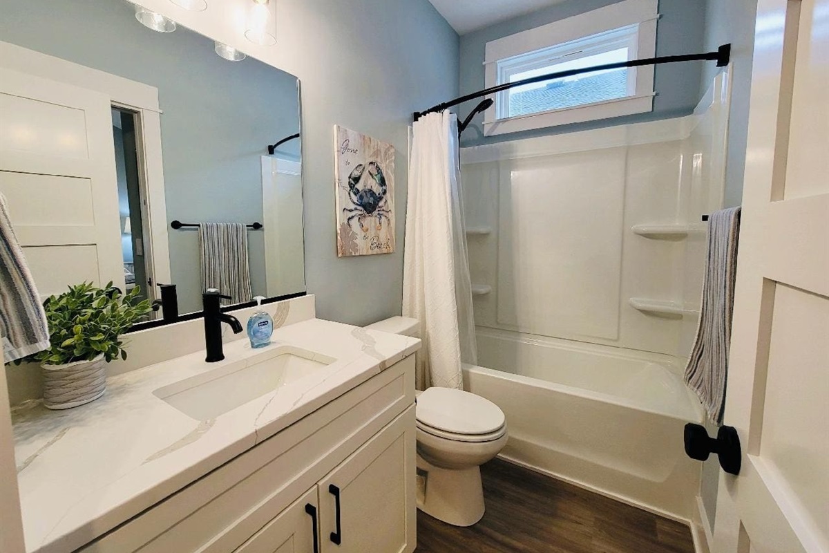 Guest bathroom has a tub and shower. 