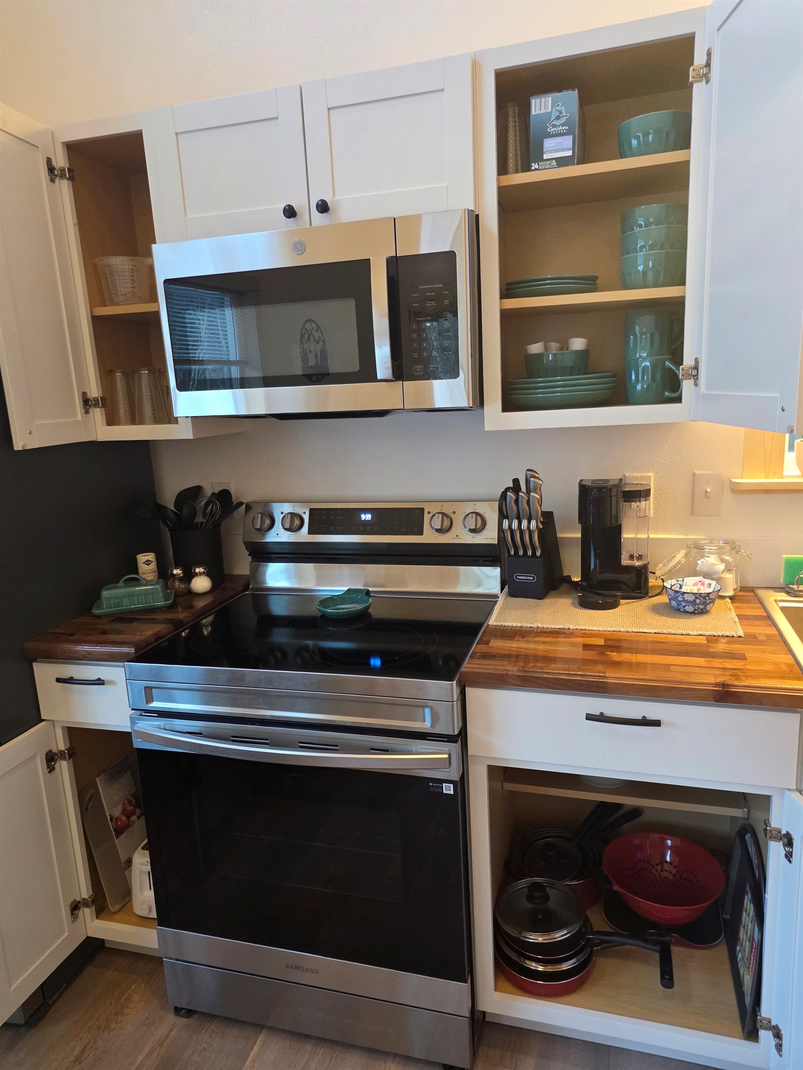 Fully stocked kitchen includes an electric range, microwave, refrigerator, and Keurig.