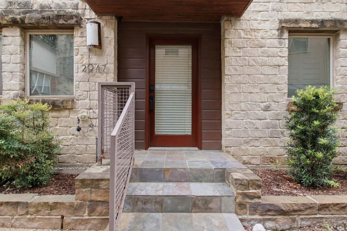 Stone and wood facade on Thomas Avenue in the State Thomas neighborhood. A modern Dallas townhome just minutes from Uptown on foot and the Design District by car.

