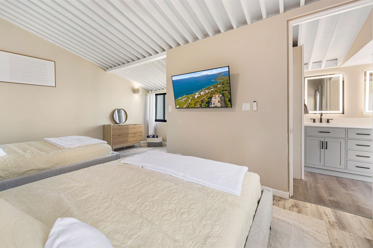 A Smart TV in the guest bedroom and the bathroom just outside the door