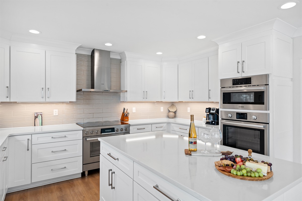 Stunning chef&rsquo;s kitchen with sleek white finishes, premium appliances, and an oversized island for gathering
