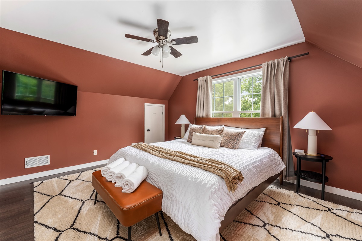 Bold, warm, and made for rest This king suite pairs rich color with cozy textures, a smart TV, and blackout curtains—because your sleep should feel as good as it looks. 🛏️🌙📺