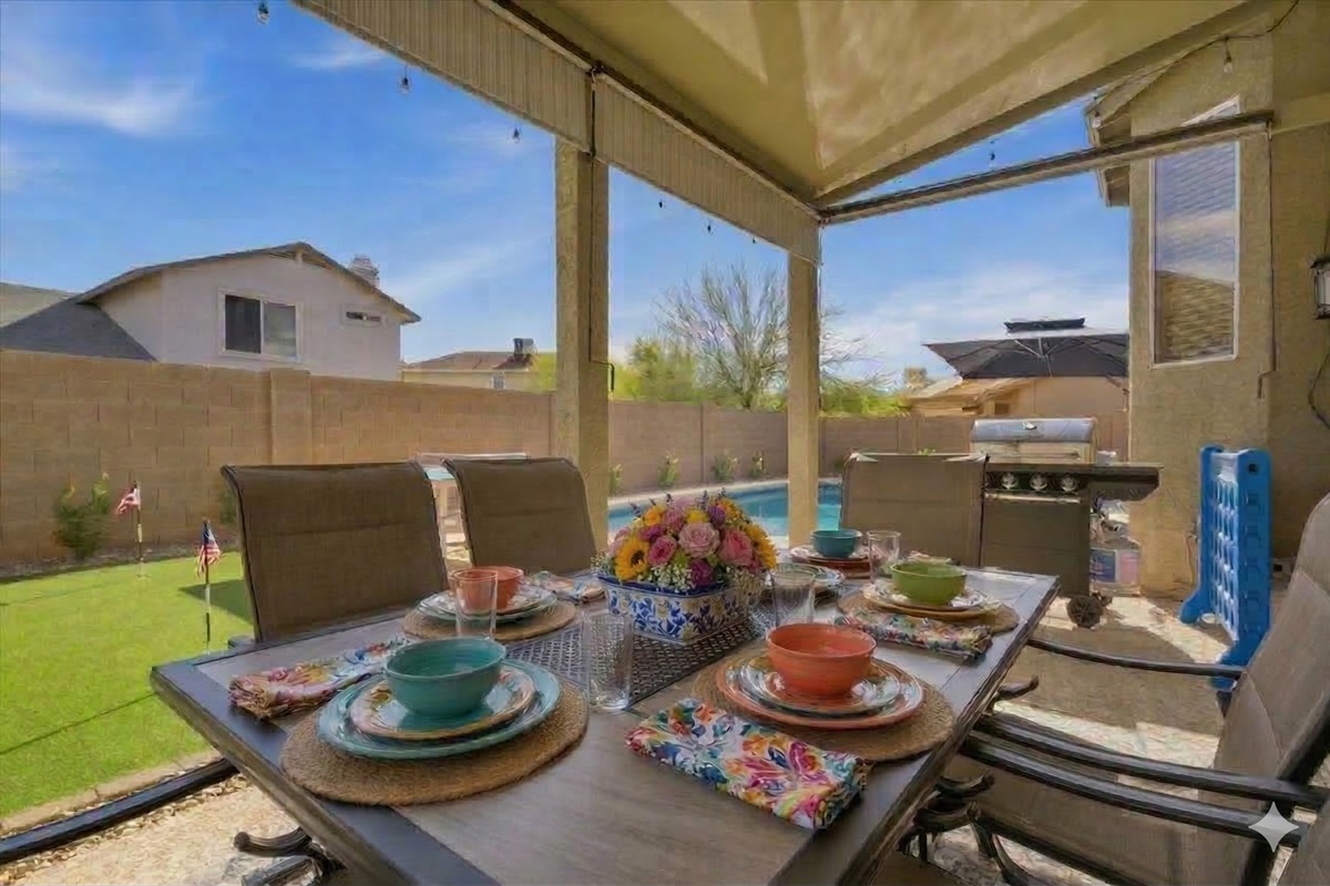 Outdoor patio has a dining table and tv (tv pictured elsewhere); it also has sun shades which are marvelous! Also pictured here is the putting green, propane grill, and giant Connect Four game.