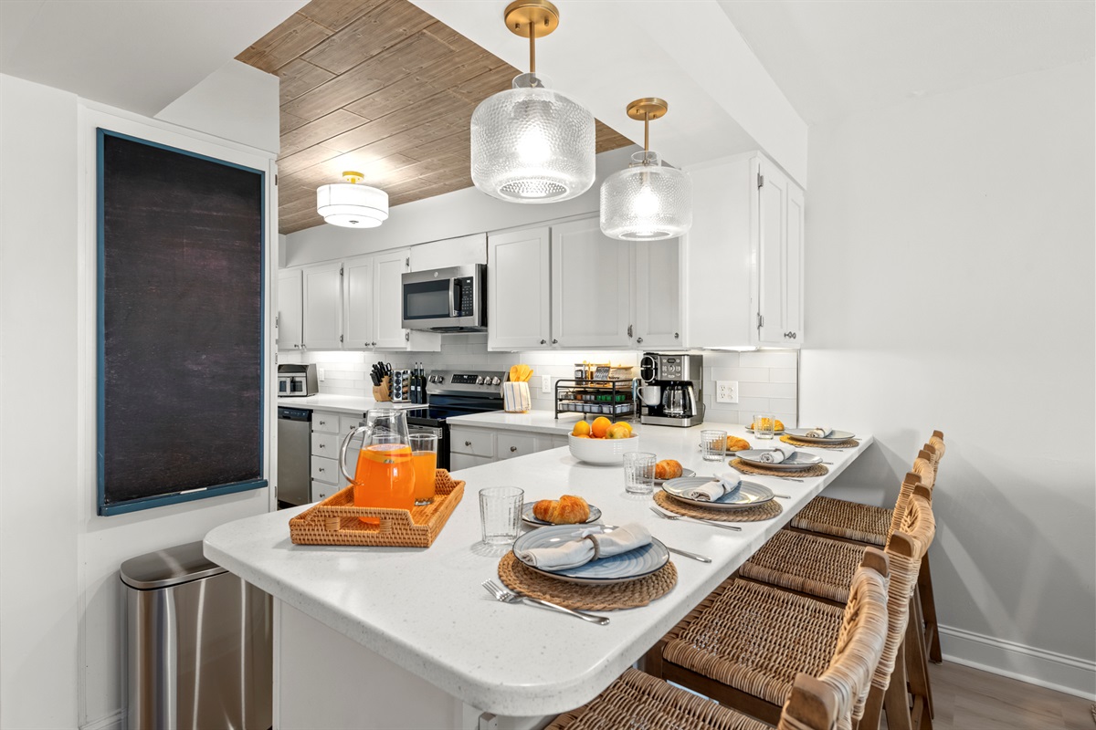 Enjoy open-concept dining with counter seating and a kitchen stocked with all the essentials for effortless meals and coastal gatherings.