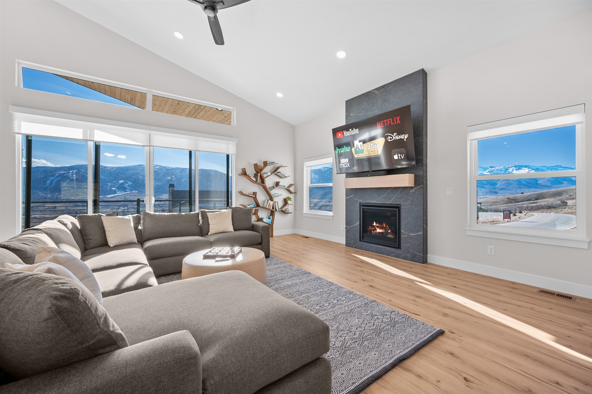 Bright, open-concept living room with mountain views, fireplace, and Smart TV in Eden, Utah.