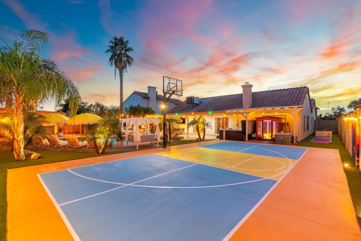 The private basketball court glows under a vivid desert sunset — game time never looked so good.