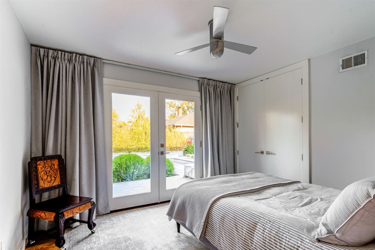 Bedroom 1 with queen bed and french doors to backyard and pool.
