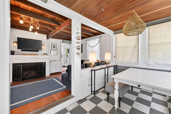 Step into this coastal cottage and you’ll find a welcoming game table and a spacious living room perfect for gathering and relaxing.
