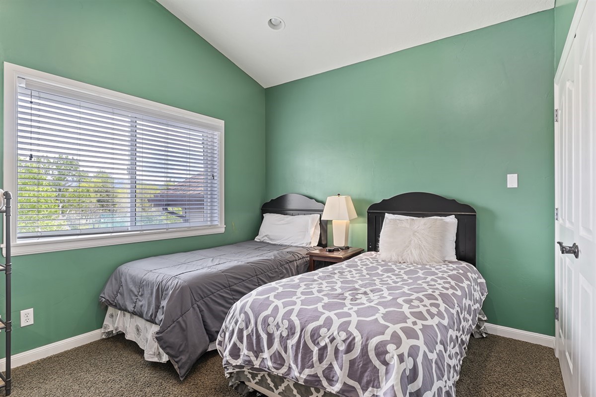 A welcoming guest bedroom with twin beds, soft natural light, and a calming palette—perfect for restful nights.