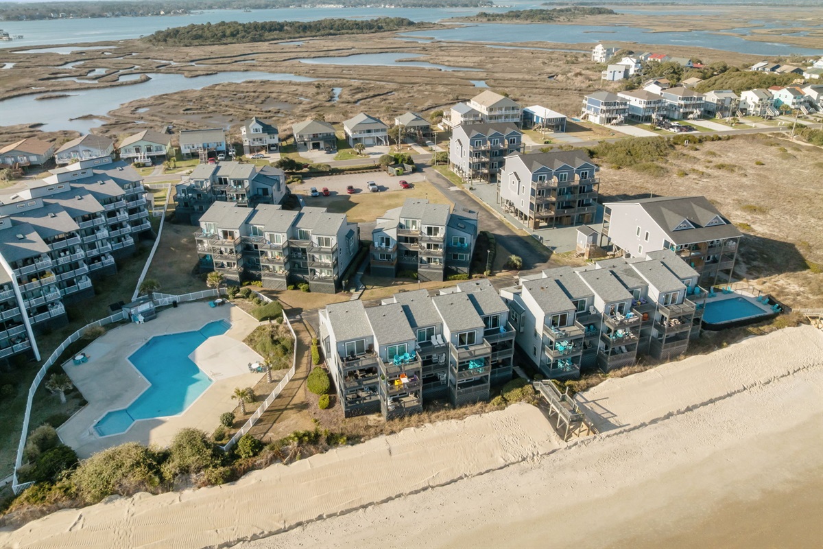 Aerial view of the community along New River Inlet Rd in North Topsail Beach, featuring direct beach access and a shared pool just steps from the sand