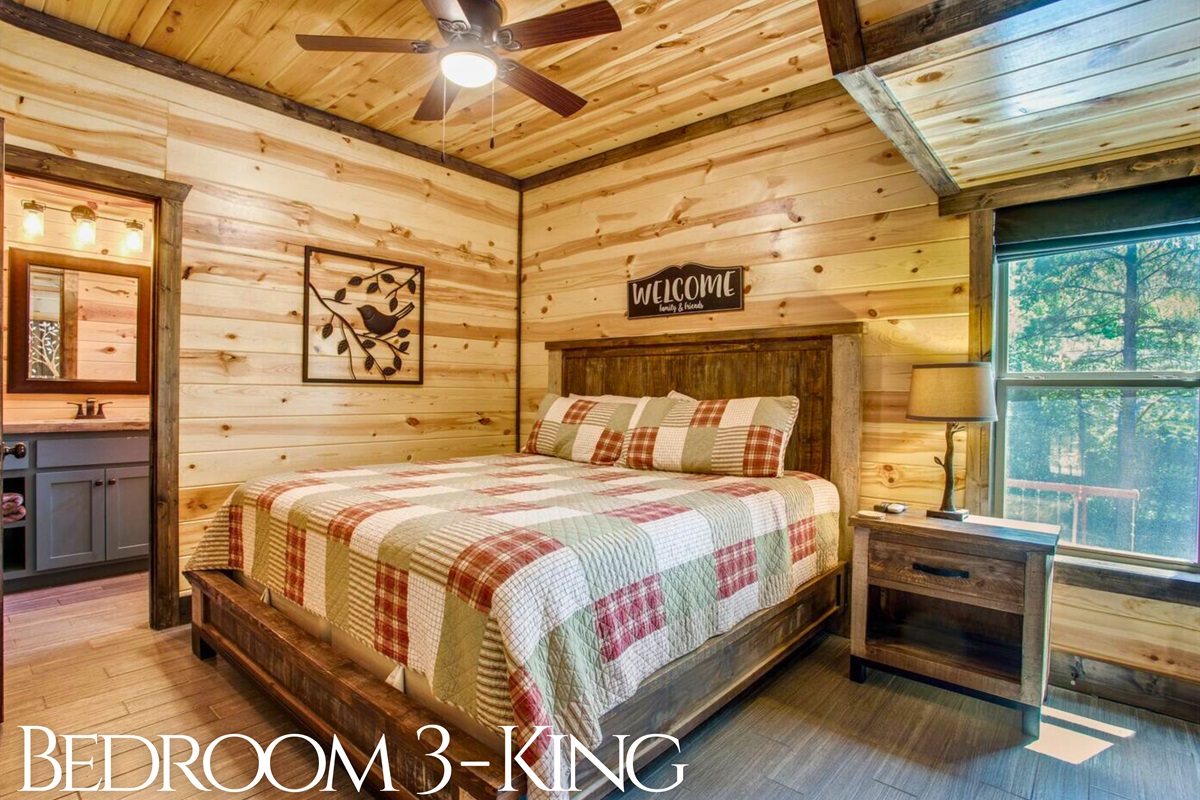 Another second floor king bedroom stands out with cozy plaid bedding and a touch of rustic charm.