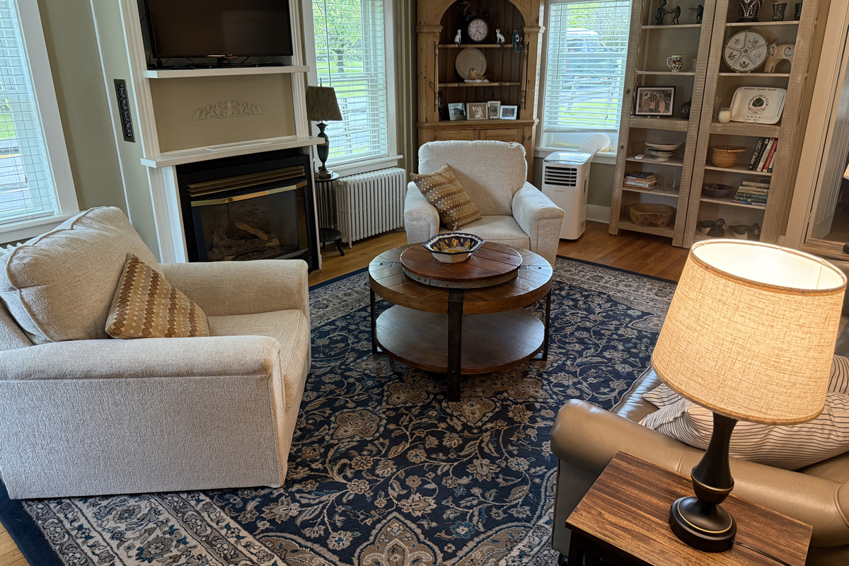 Warm and inviting living room with cozy fireplace, comfortable seating, and charming built-in details.