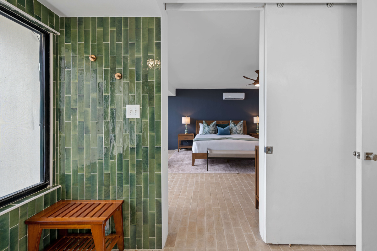 Sliding barn door separates the bathroom from the primary bedroom.