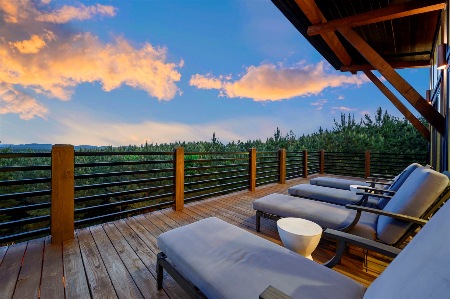 Modern Broken Bow cabin with expansive second-story deck, outdoor lounge seating, and breathtaking sunset views.