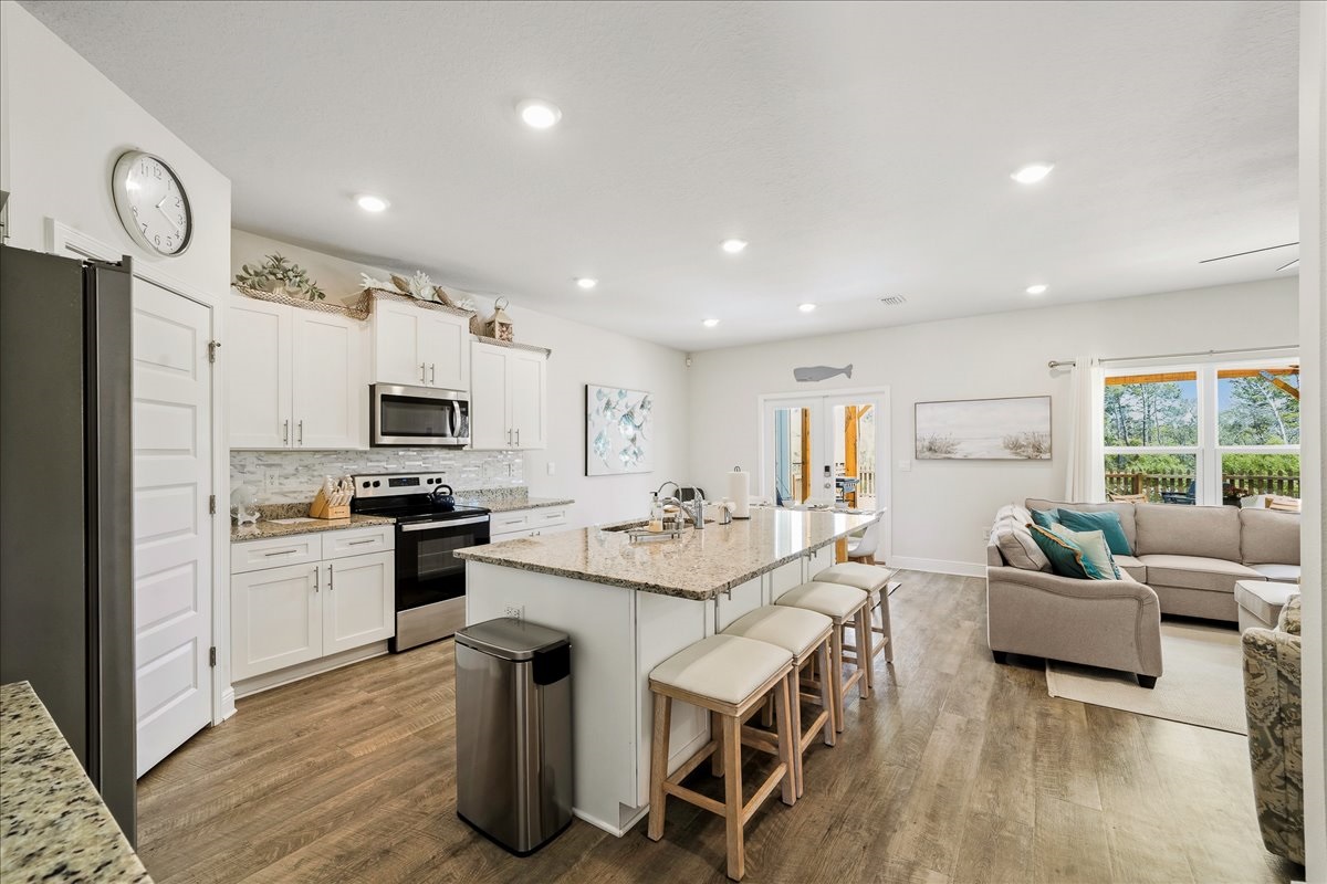 fully stocked with stainless steel appliances and a kitchen island with seating for four.