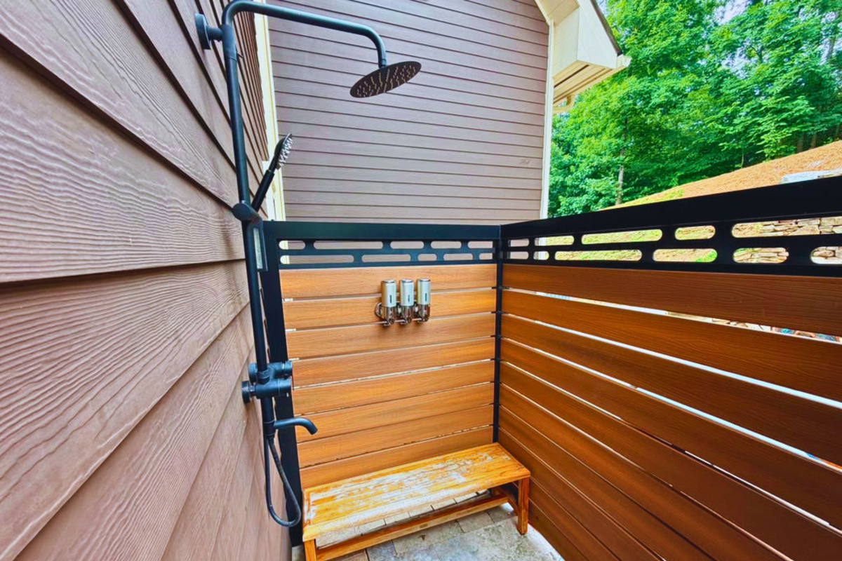 Refresh in total privacy. Surrounded by warm wood tones and a contemporary matte black privacy fence, this serene outdoor shower enclosure offers a spa-like retreat right in nature's lap.
