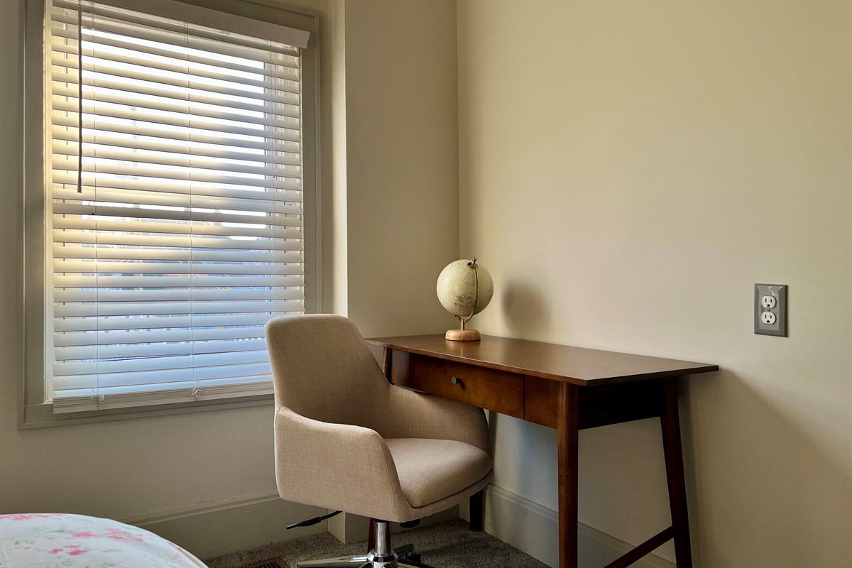 Bedroom 1 features a small desk and comfortable office chair.