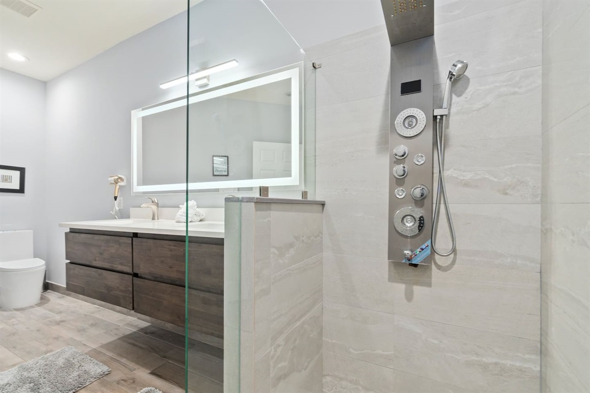 Updated bathroom featuring a glass walk-in shower, modern vanity, tile finishes, and a clean spa-like feel.
