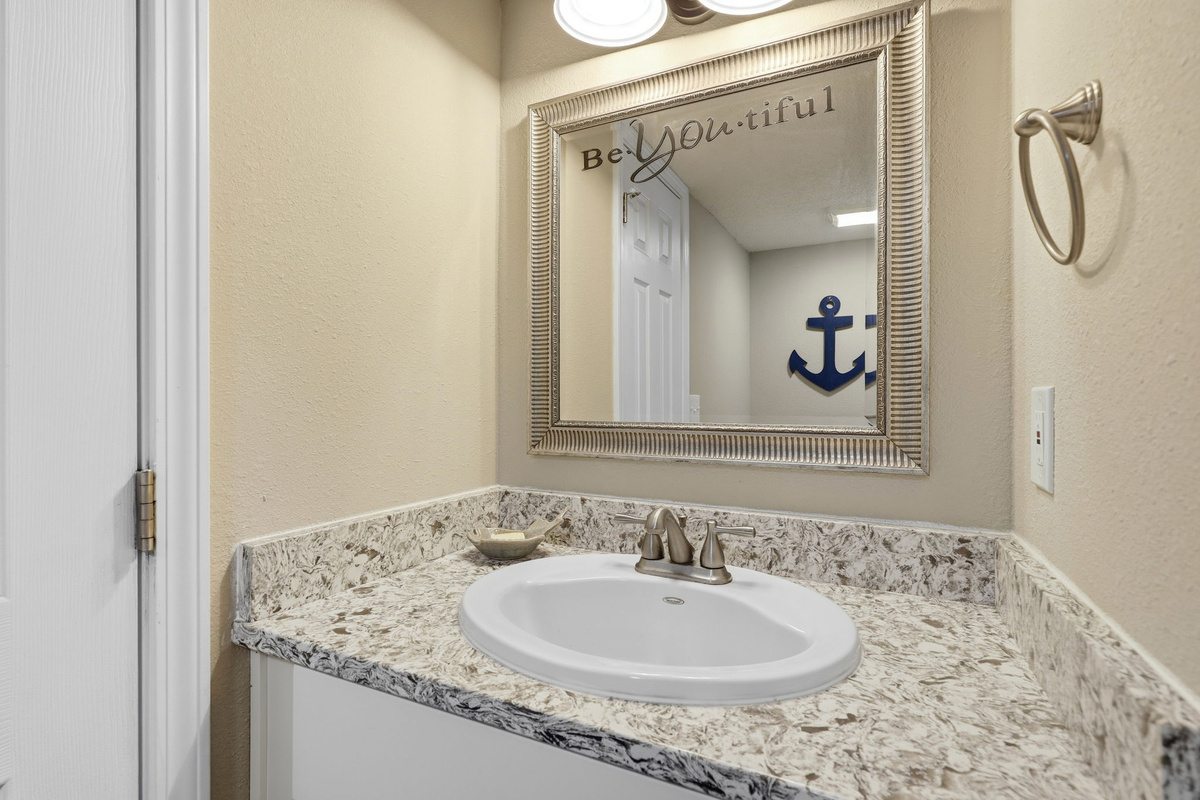 BeYOUtiful memories are made by the coast! Thoughtfully placed half bath perfect for guests gathering in the main living space.