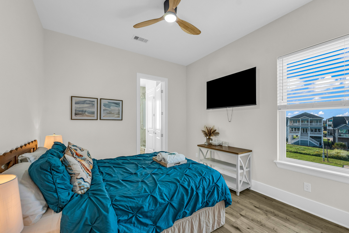 Costa Cristal Bedroom 5: Modern and comfortable bedroom featuring a neatly made bed, a wall-mounted TV, and a window that brings in plenty of light, creating a welcoming atmosphere.