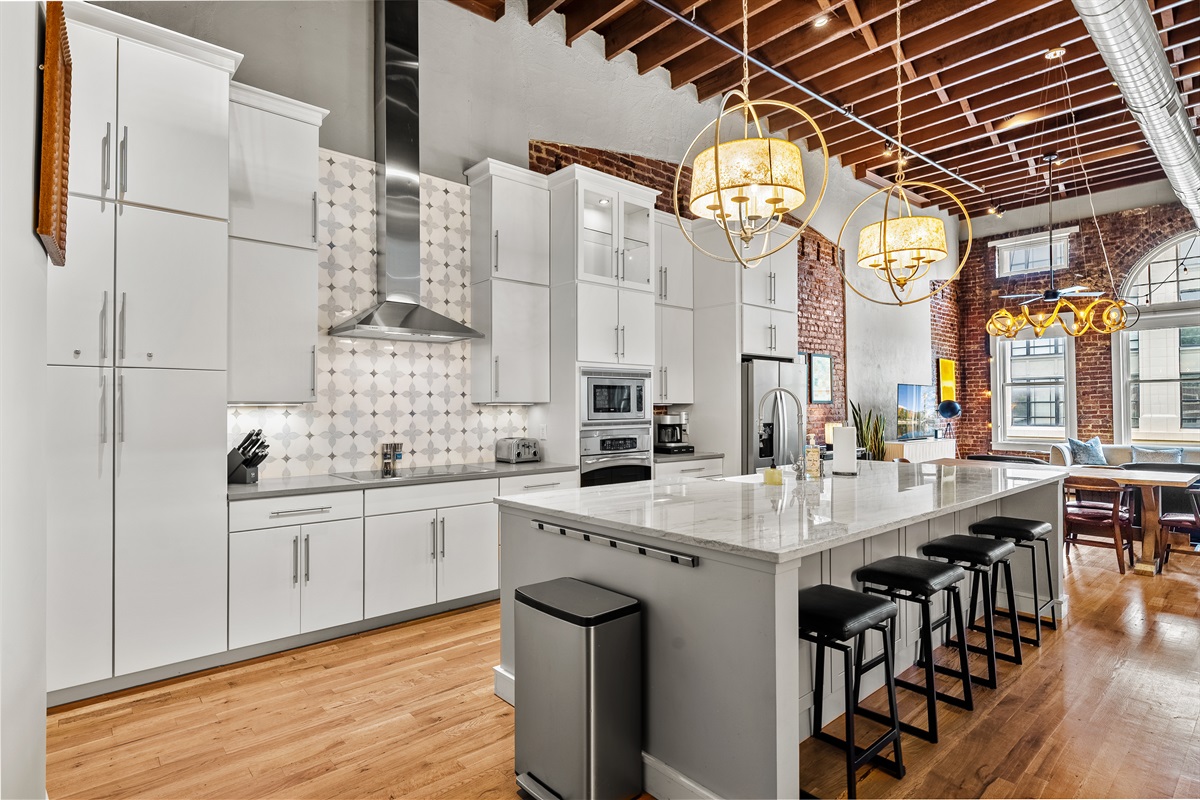 Fully equipped chef’s kitchen with granite countertops and bar seating.