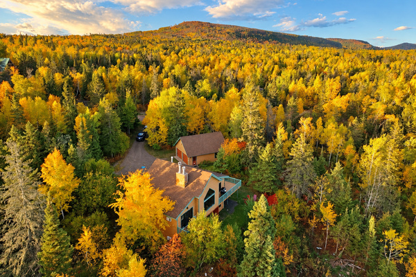 Nestled among brilliant golden aspens and vibrant autumn foliage, this secluded North Shore cabin shown with Laveaux Mountain in the background. Experience the magic of Minnesota’s fall colors, surrounded by peaceful forest!