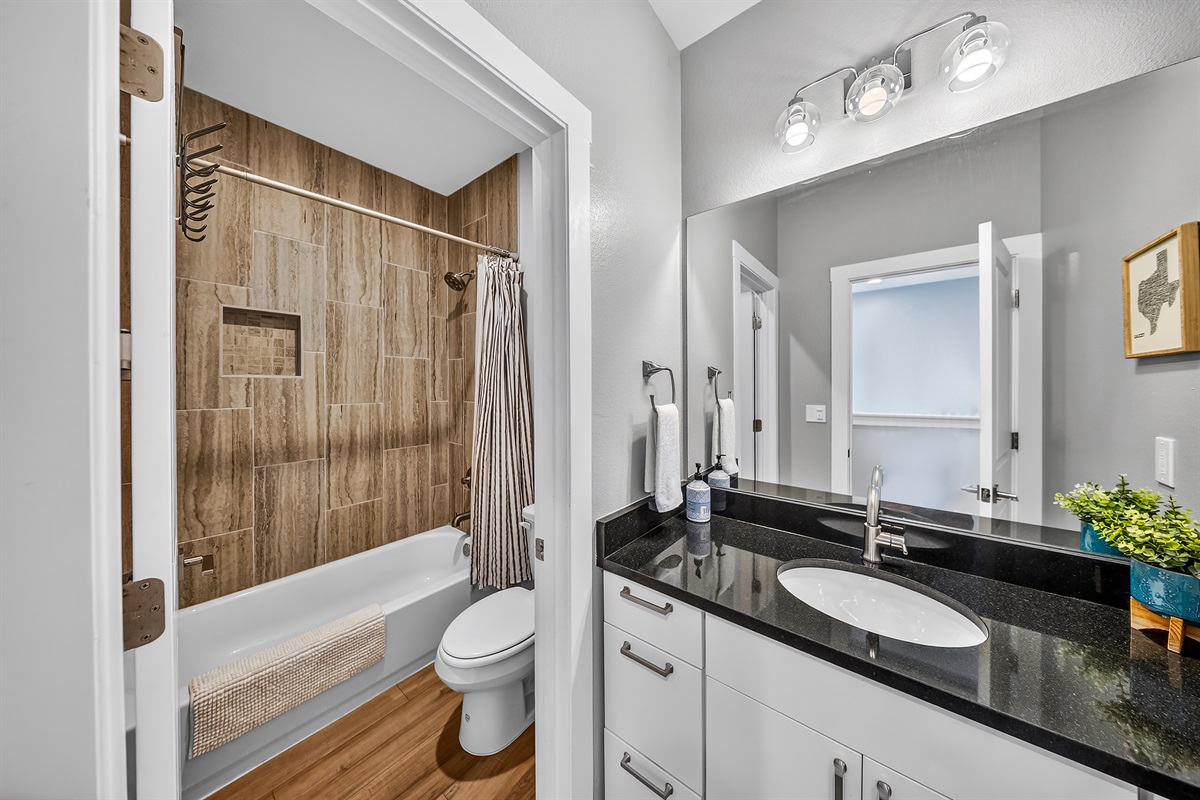 - Guest bathroom with sleek vanity and stylish finishes throughout - Bright mirror and clean layout perfect for quick daily routines - Connected bath area adds comfort function and easy lake living