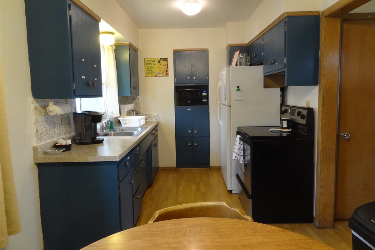 Kitchen with full stove and refrigerator