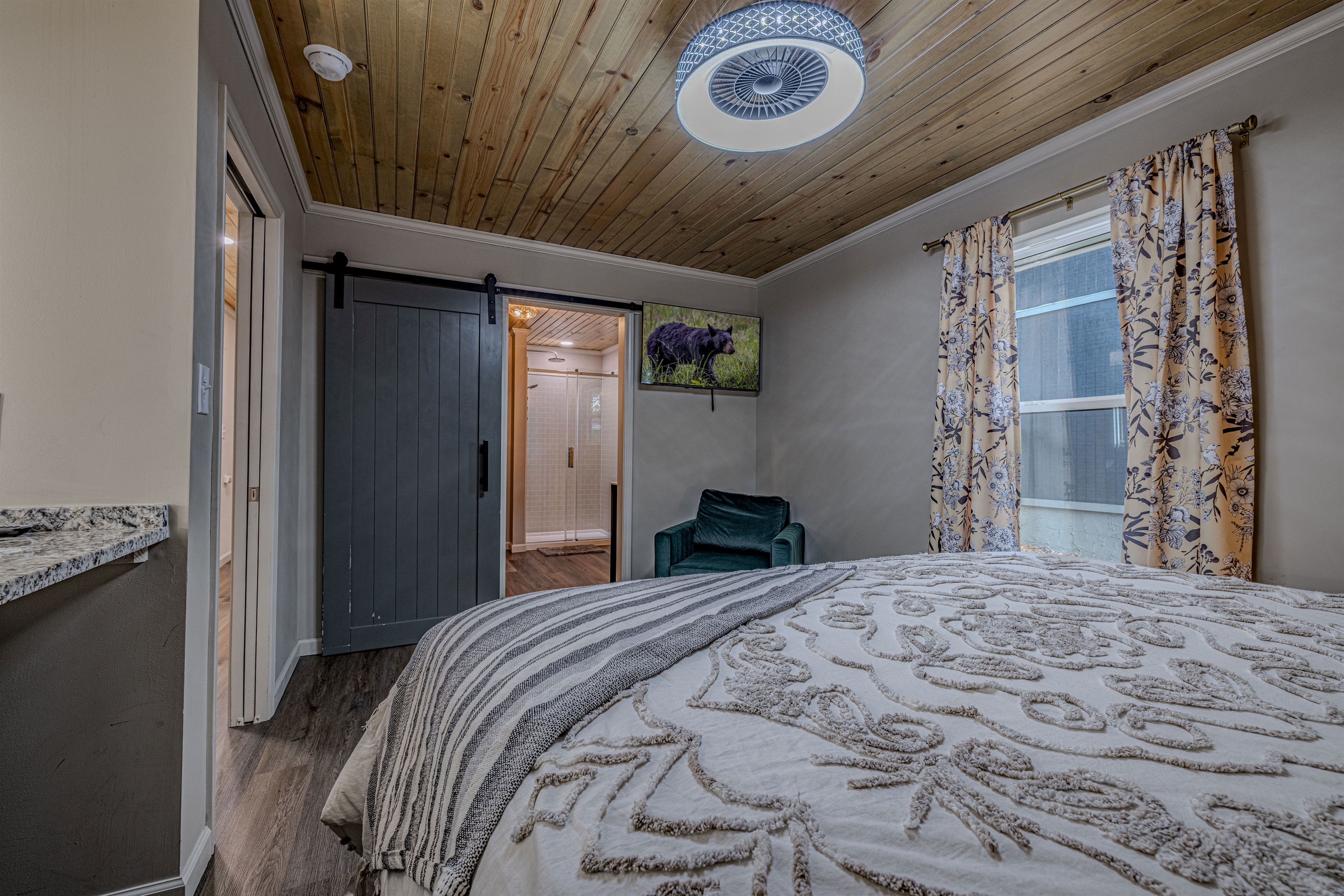 Sink into the plush, patterned bedding and enjoy the quiet atmosphere of the forest. The velvet accent chair offers a perfect corner for morning reflection.