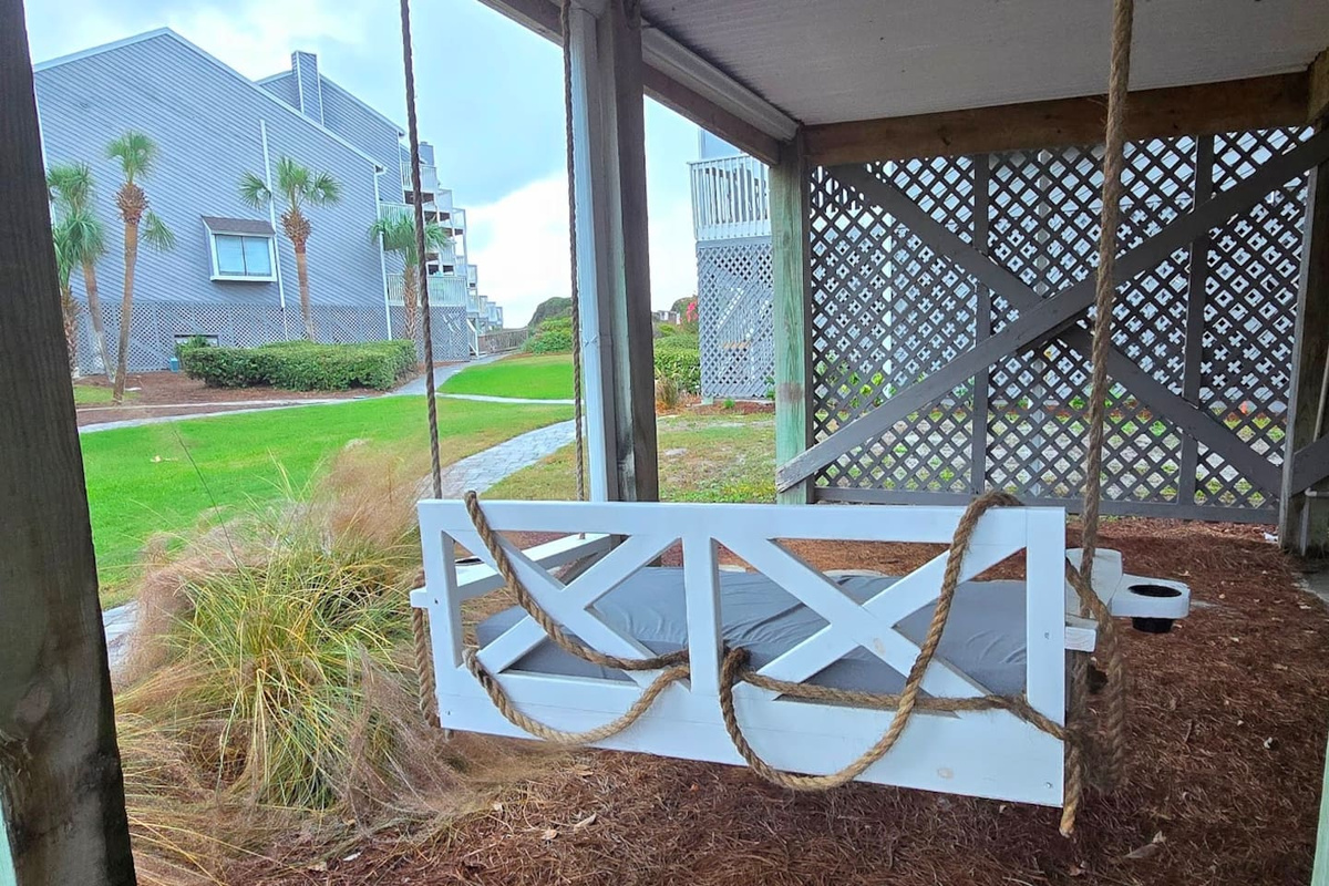 Settle into the oversized covered swing at ground level and let the Gulf breeze handle the rest &mdash; the kind of afternoon you drove here for.