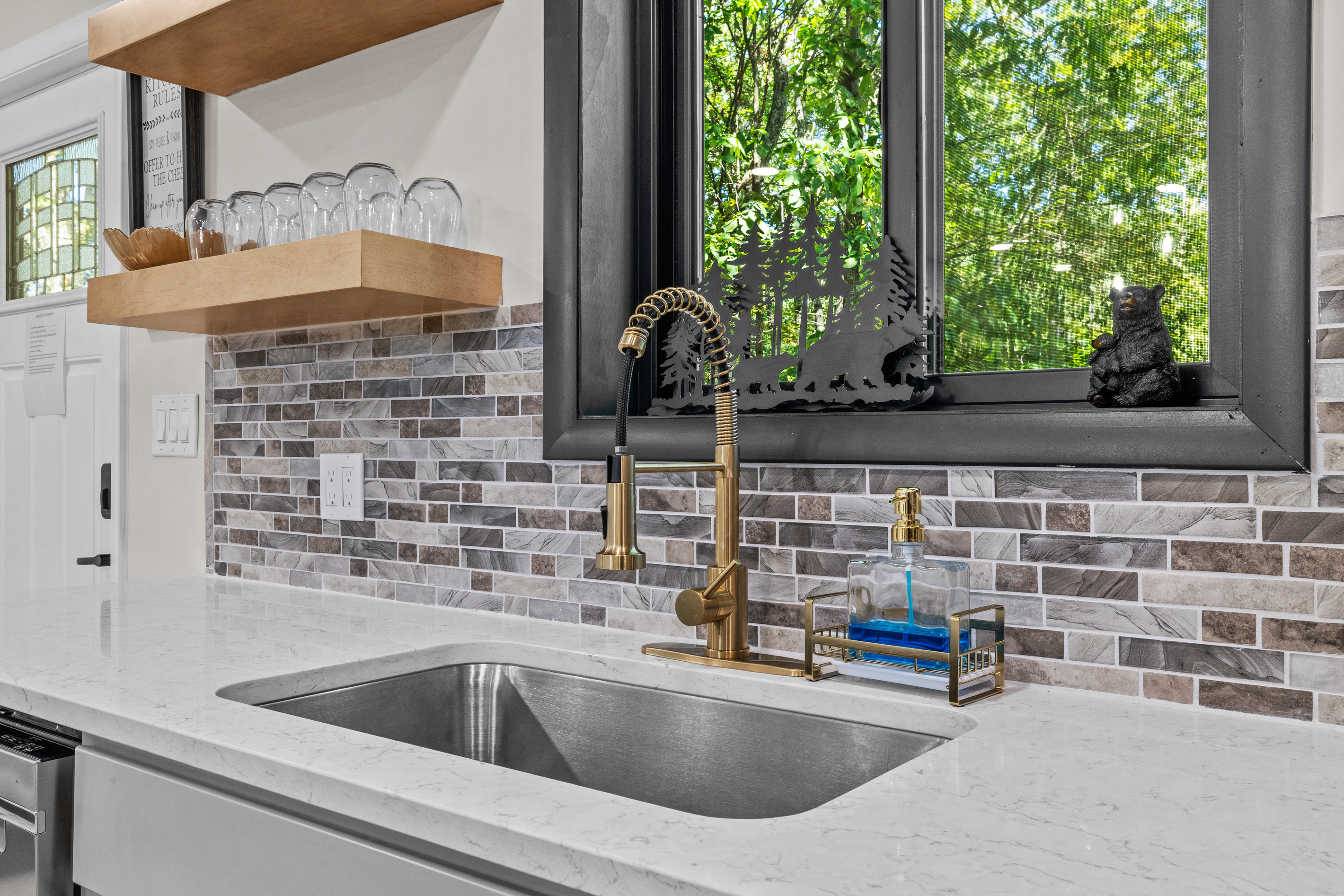 Undermount beneath a large window that frames peaceful forest views