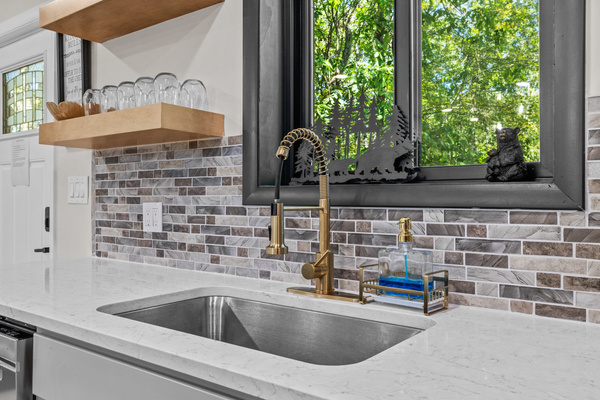 Undermount beneath a large window that frames peaceful forest views