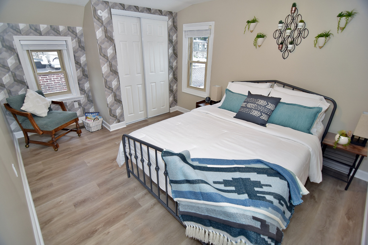 First bedroom with a queen-sized bed, reading area, and closet.