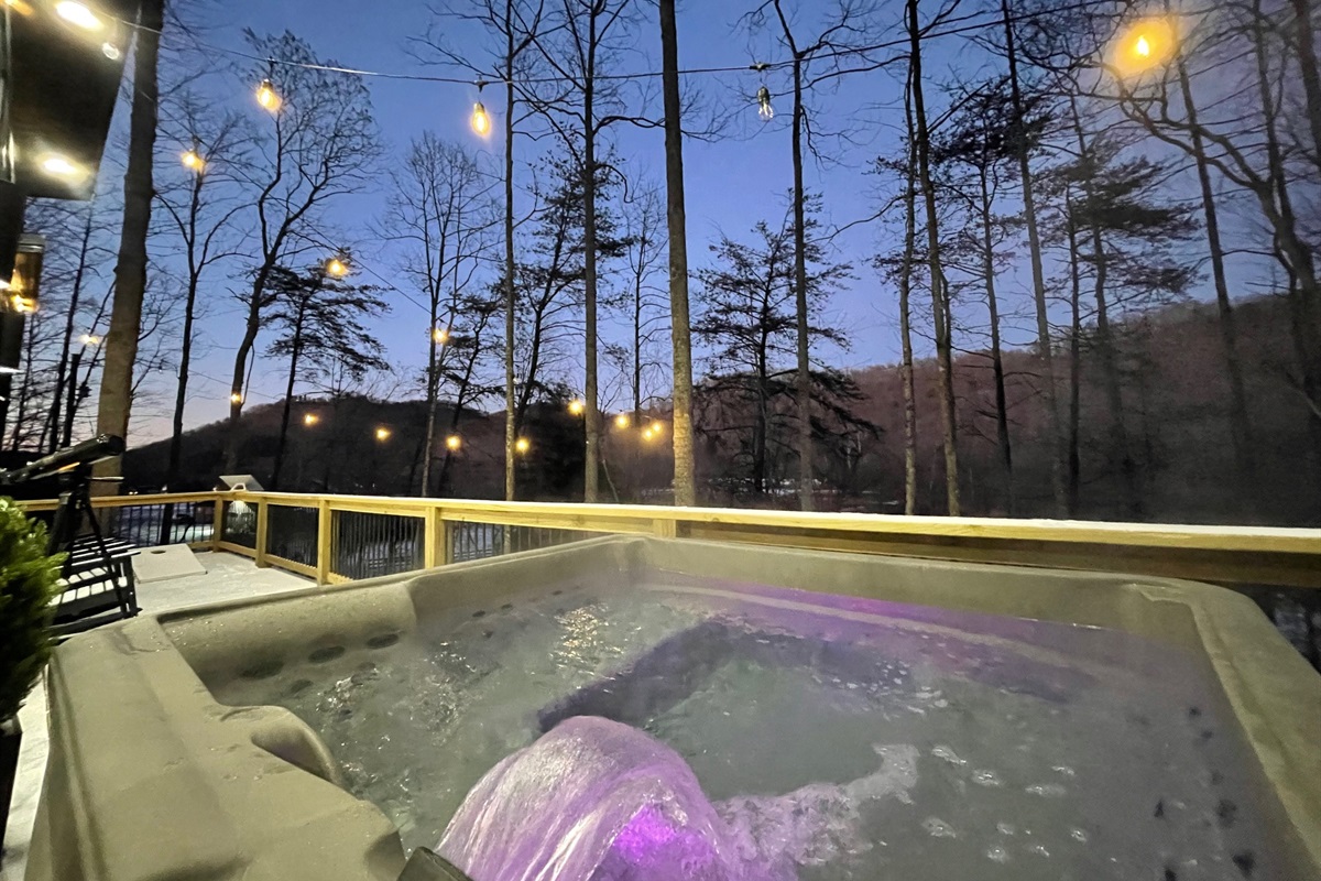 Private hot tub under the stairs | mountain view, cozy deck lighting, and perfect for peaceful & romantic evenings. 