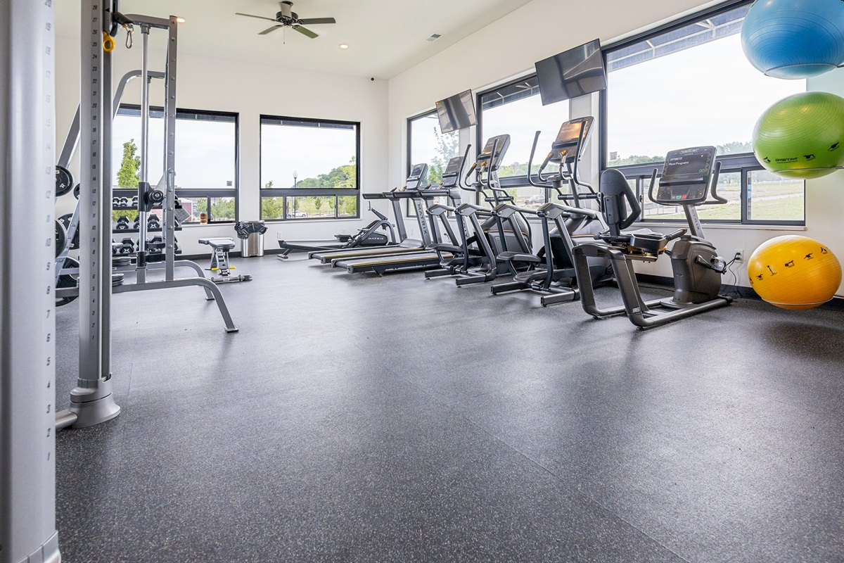 Modern fitness center featuring cardio and strength-training equipment. Membership required and available separately through the facility.