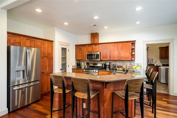 Wrapping around the kitchen is an eat-in bar with beautiful granite countertops. The bar has 6 barstools, providing ample seating for guests. Perfect spot to sip a glass of wine and chat with your friends while your chef finishes up dinner. 