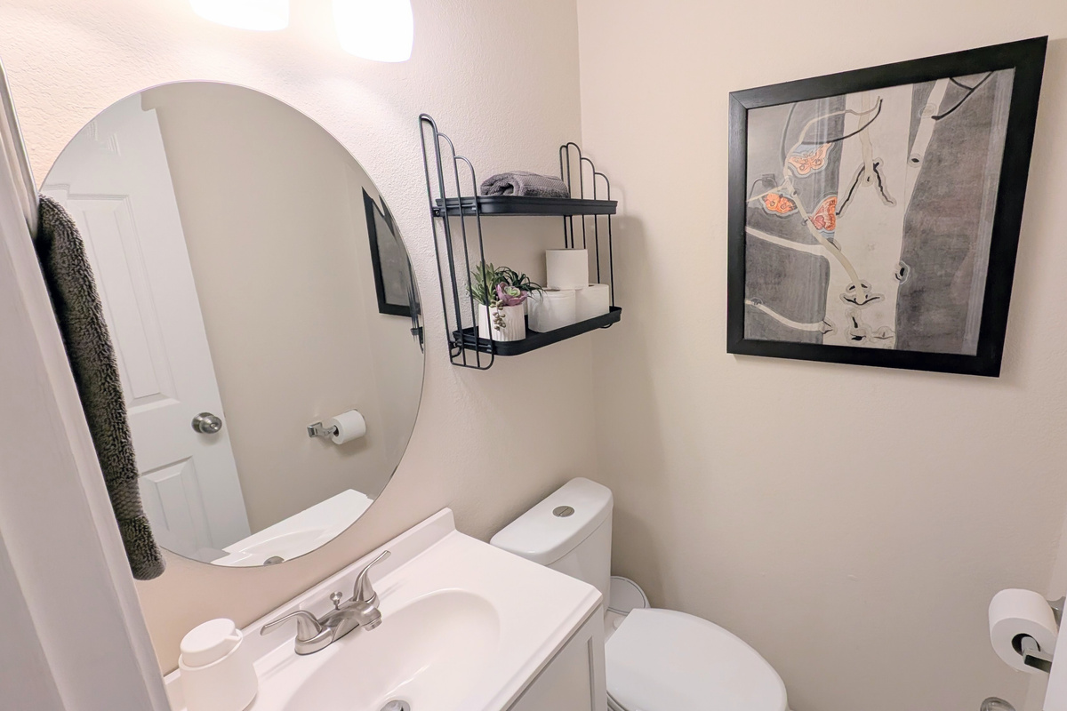 Convenient half bath is located near the downstairs living space and is stocked with foaming hand soap, fluffy towels, and water efficient toilet.