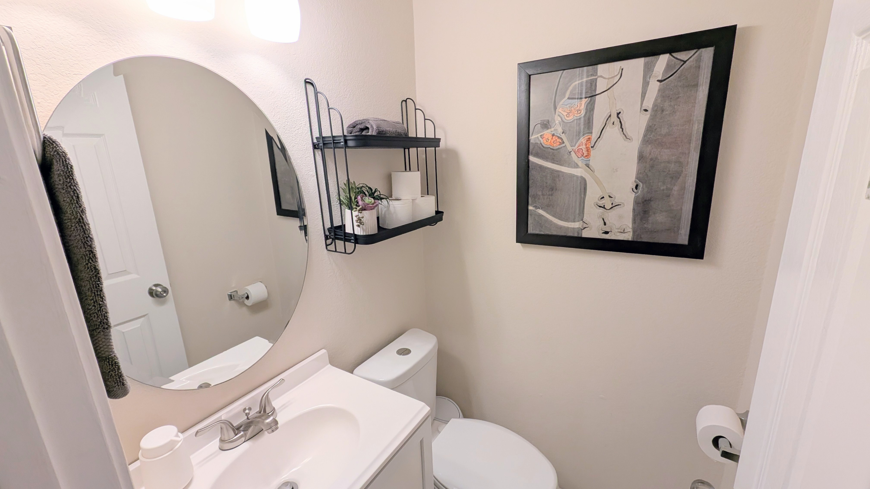 Convenient half bath is located near the downstairs living space and is stocked with foaming hand soap, fluffy towels, and water efficient toilet.