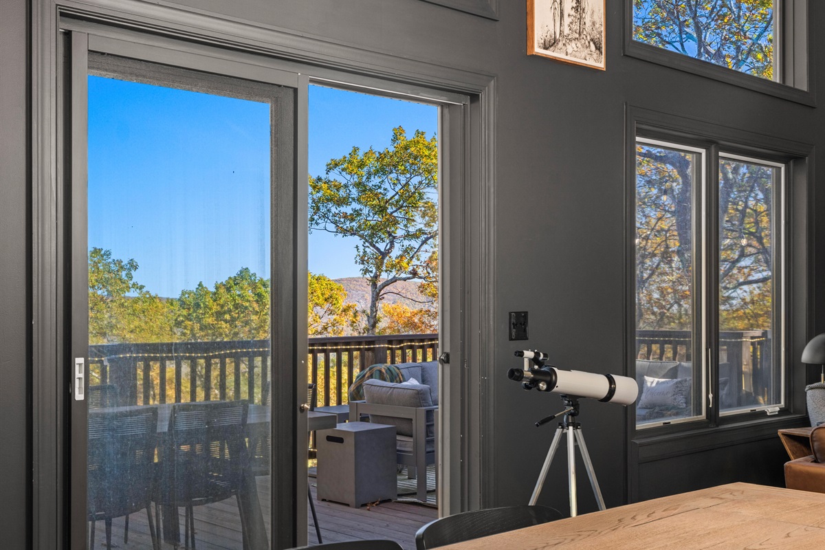 Modern dining view—floor-to-ceiling glass invites you onto the deck to take in mountain scenery and vibrant fall color