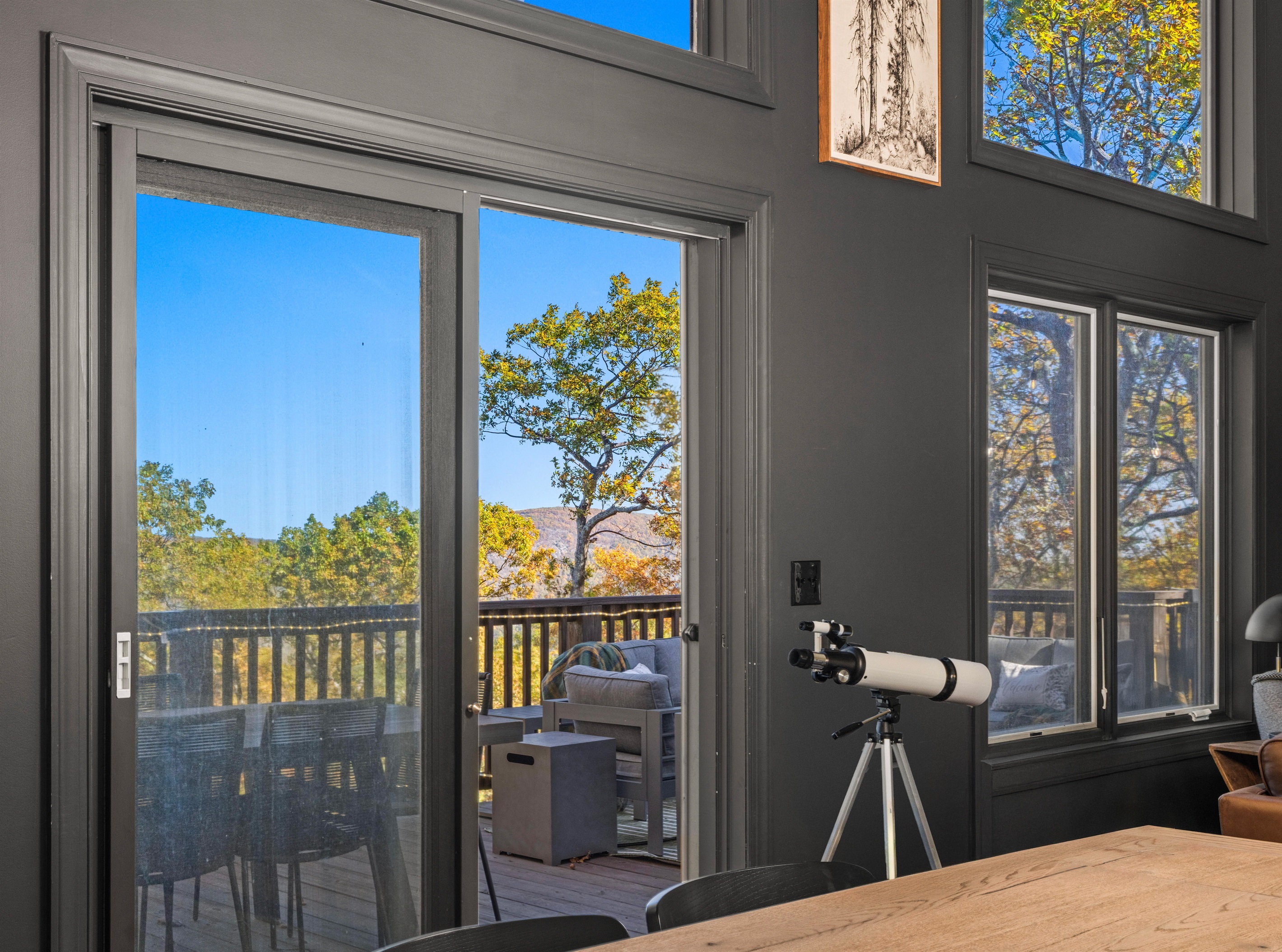 Modern dining view—floor-to-ceiling glass invites you onto the deck to take in mountain scenery and vibrant fall color
