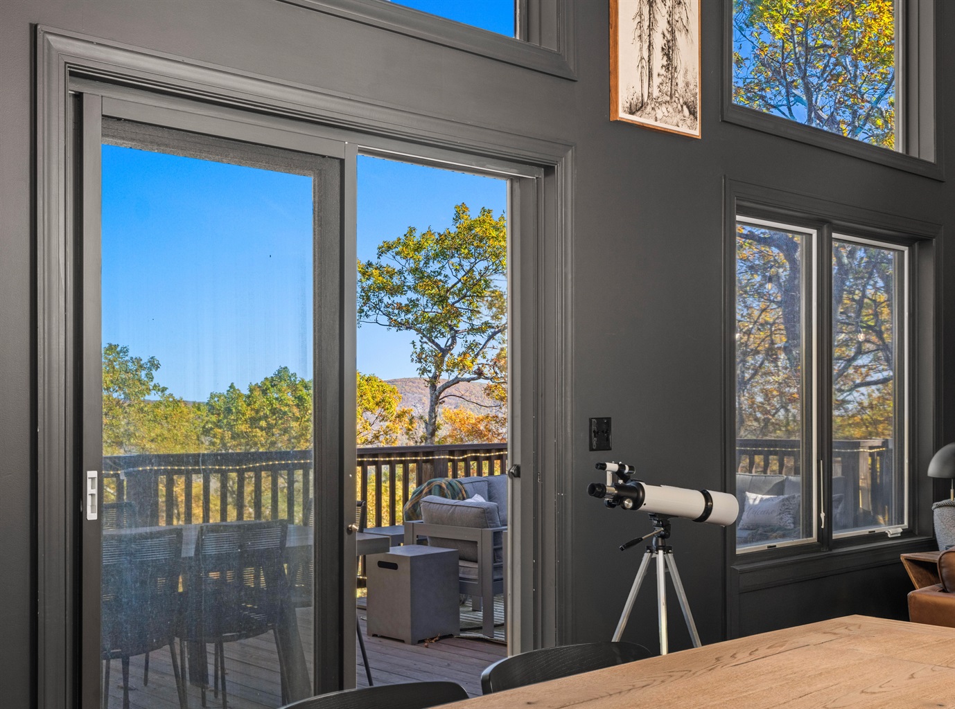 Modern dining view—floor-to-ceiling glass invites you onto the deck to take in mountain scenery and vibrant fall color