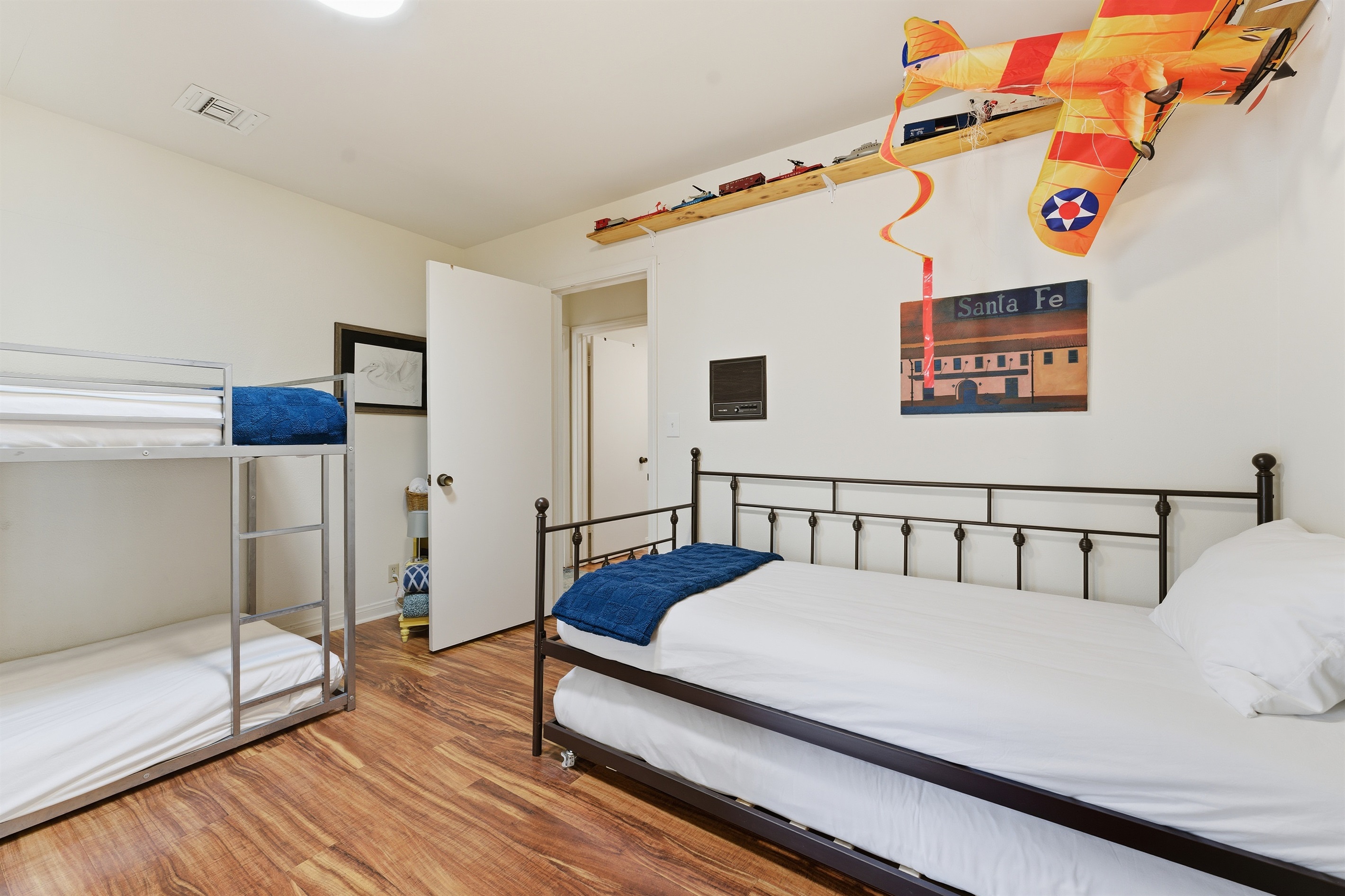 Kids room with a day bed and bunk beds for a total of 4 twin beds