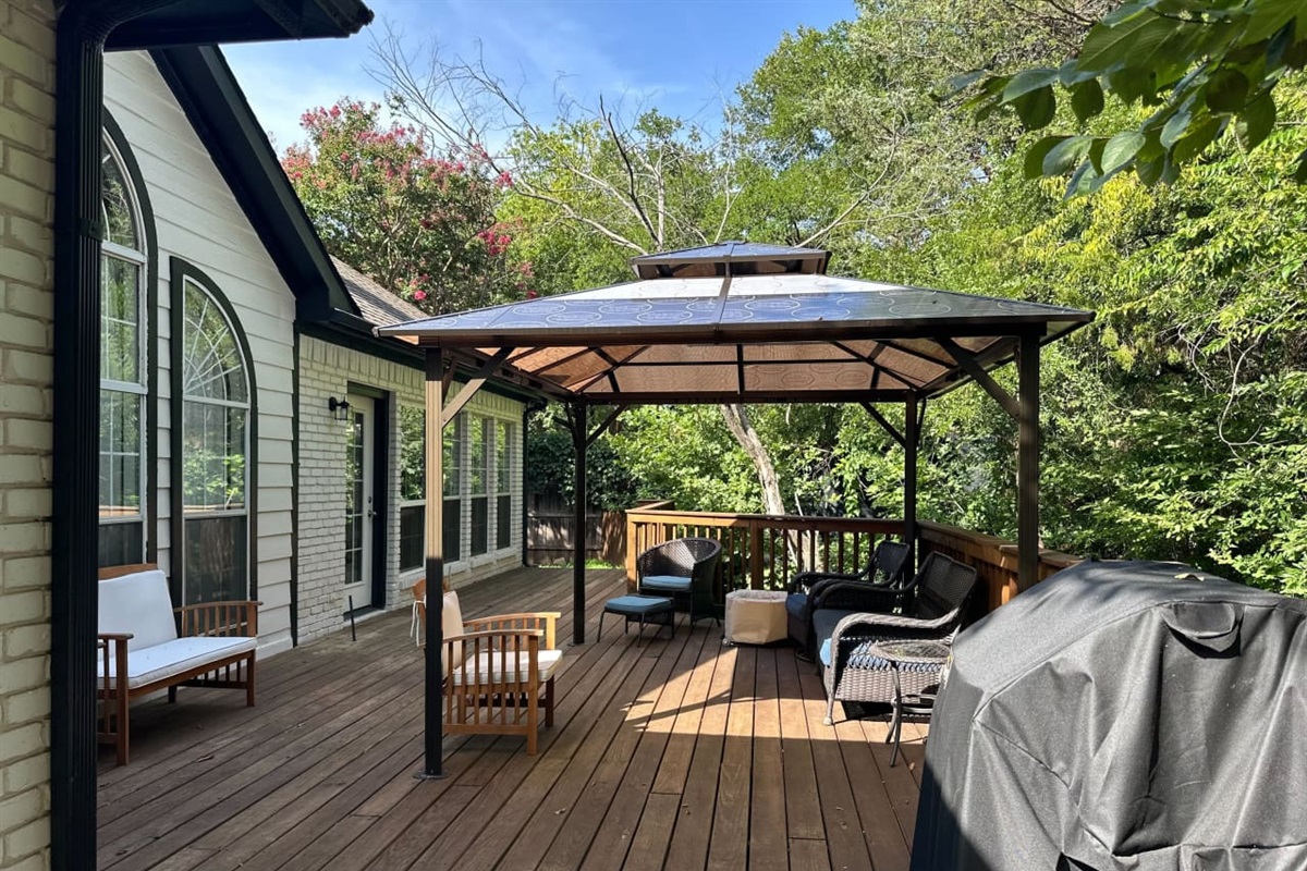 Covered patio with grill for outdoor dining and entertaining.