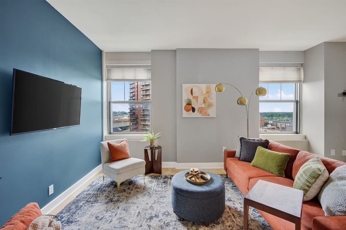 Gather in a stylish living room with skyline views, modern decor, and a bold accent wall. Sink into the vibrant sofa, stream your favorites on the flat-screen TV, or enjoy conversation bathed in natural light; perfect for city escapes.