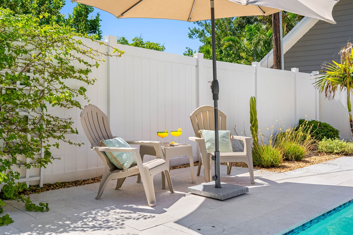Lounge in luxury with in-water sun chaises, vibrant landscaping, and total privacy behind a fenced yard.