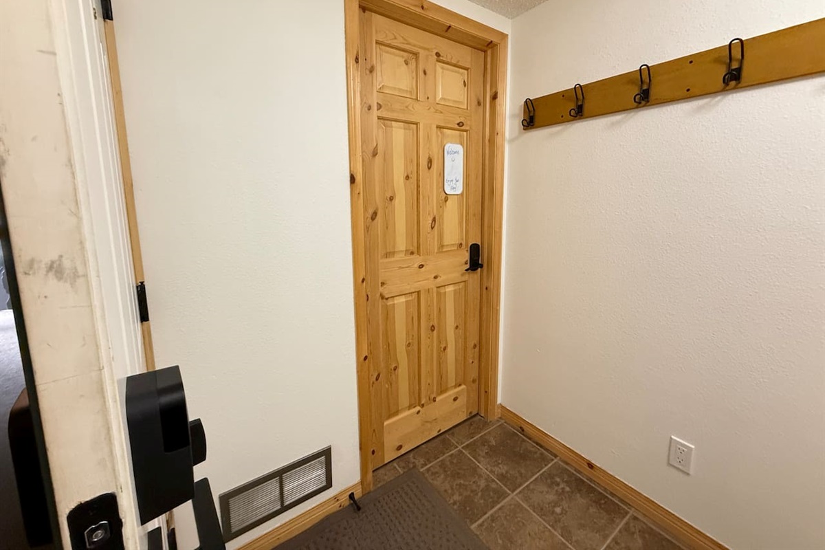 Shared entry leading to your private bed and bath, secured with a smart lock and your own code. A solid pine door and cozy mountain touches ensure comfort and privacy throughout your stay.