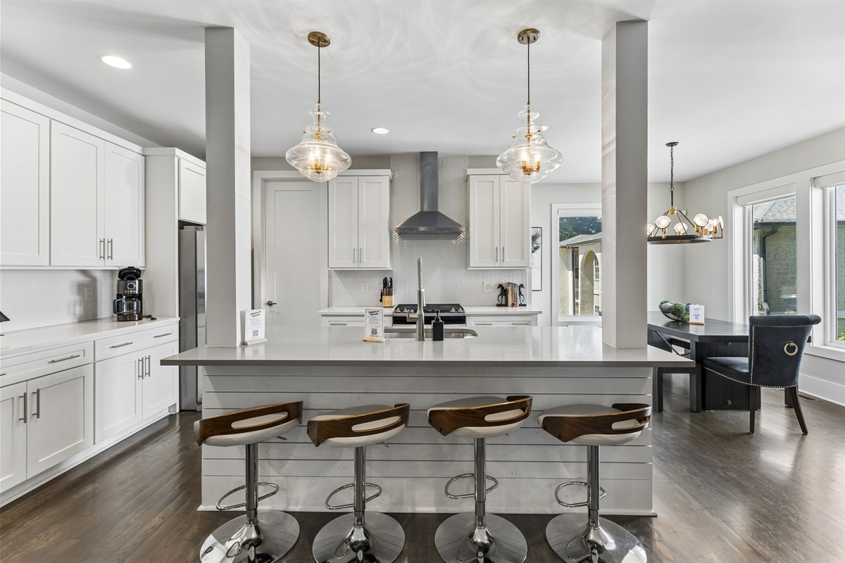 Gather around the quartz island &mdash; bar seating for four, gas range behind, and everything a group of ten needs to cook together.