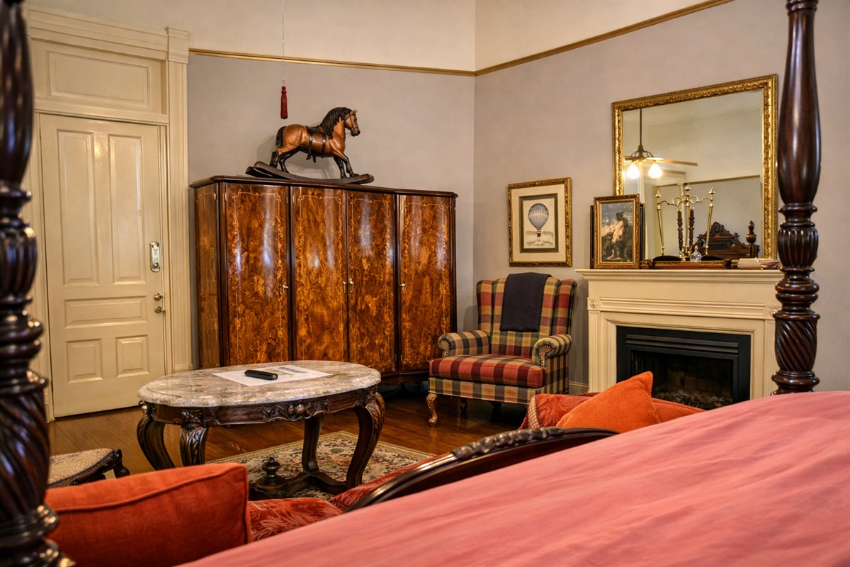Alternate angle of the suite highlighting the antique armoire, fireplace, and seating area.