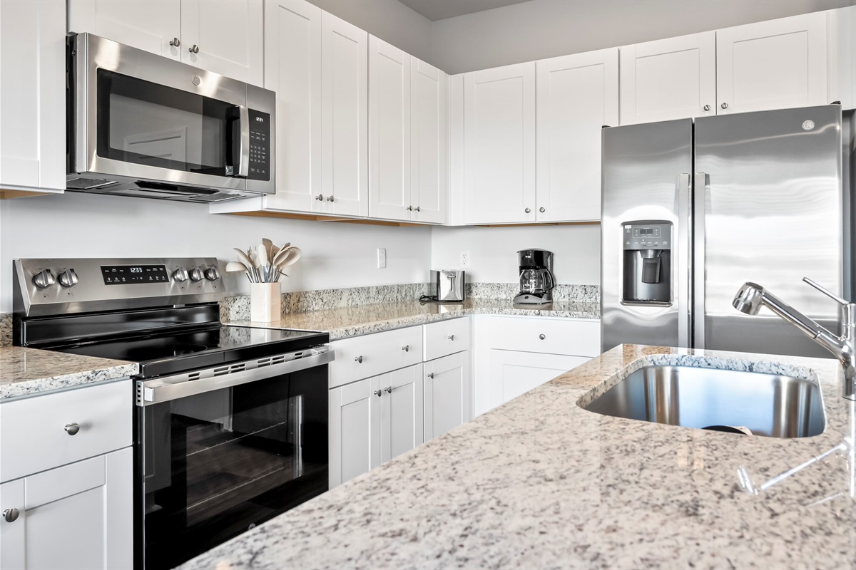 New kitchen with stainless steel appliances and granite countertops