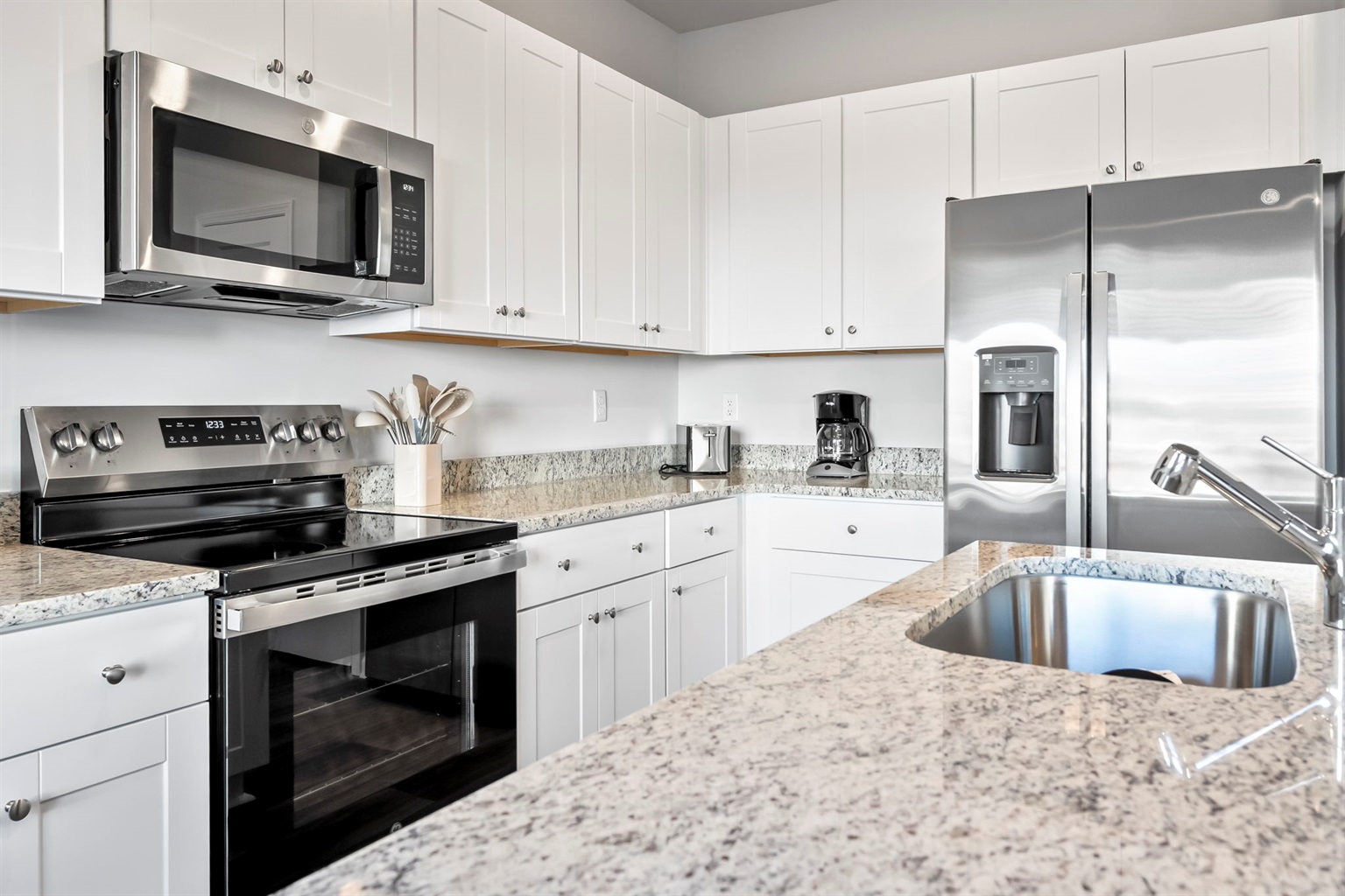 New kitchen with stainless steel appliances and granite countertops